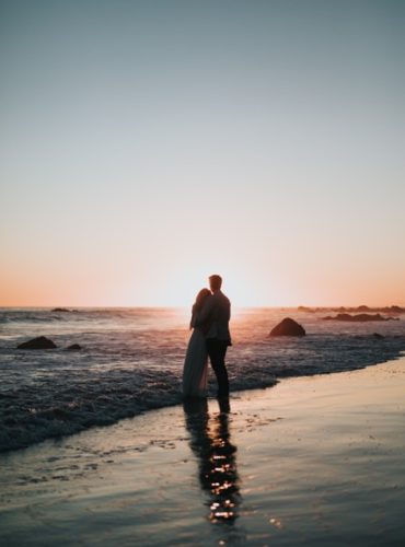 Just married couple enjoying a sunset at a beach